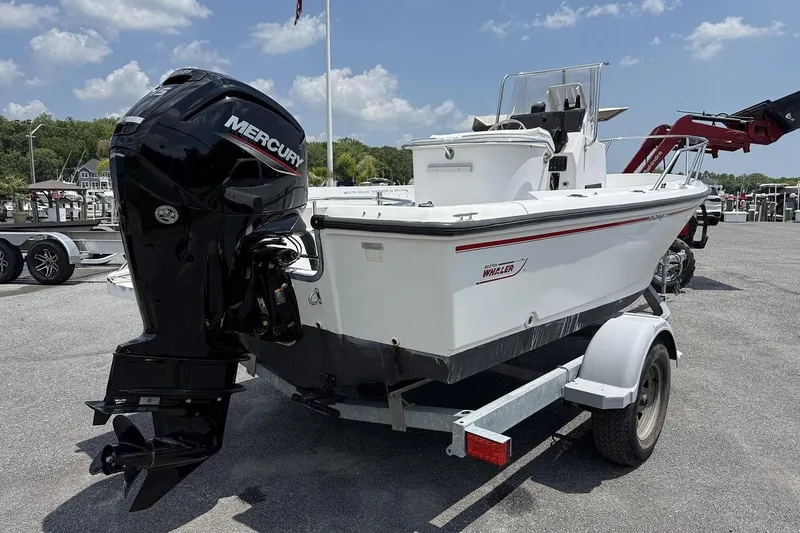 Slide: The Image of 1996 Boston Whaler Outrage 17 boat with Mercury engine on trailer, parked outdoors. - 2