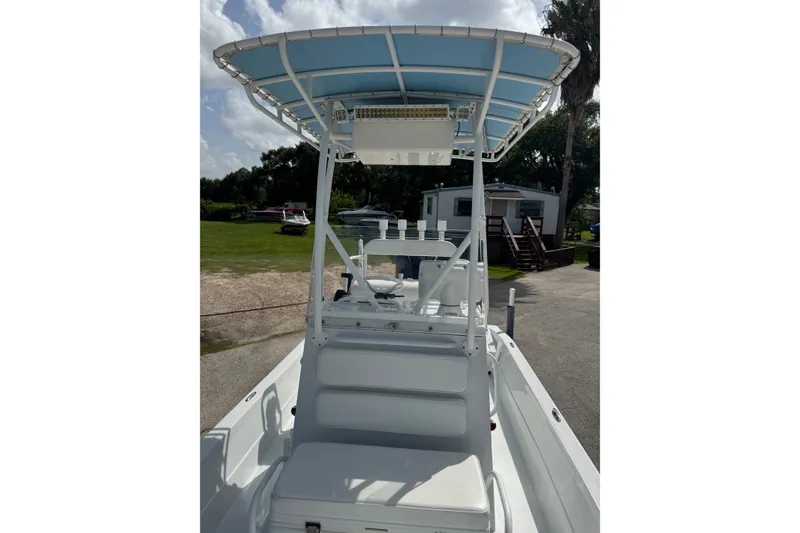 Slide: The Image of 2012 Shallow Sport 21 Modified V boat with blue canopy and white seating. - 31