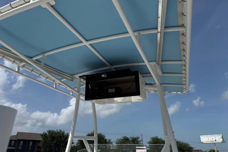Slide: The Image of 2012 Shallow Sport 21 Modified V boat canopy with blue cover under clear sky. - 18