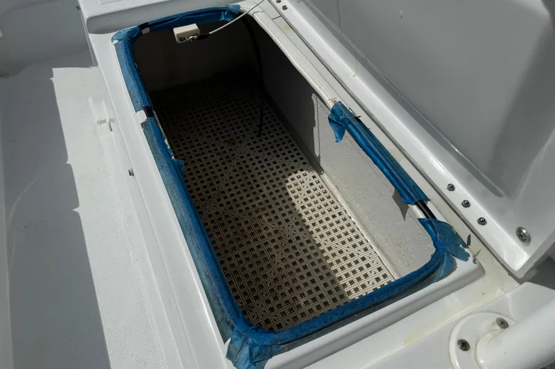 Slide: The Image of Storage compartment of a 2012 Shallow Sport 21 Modified V boat, featuring blue tape lining. - 14