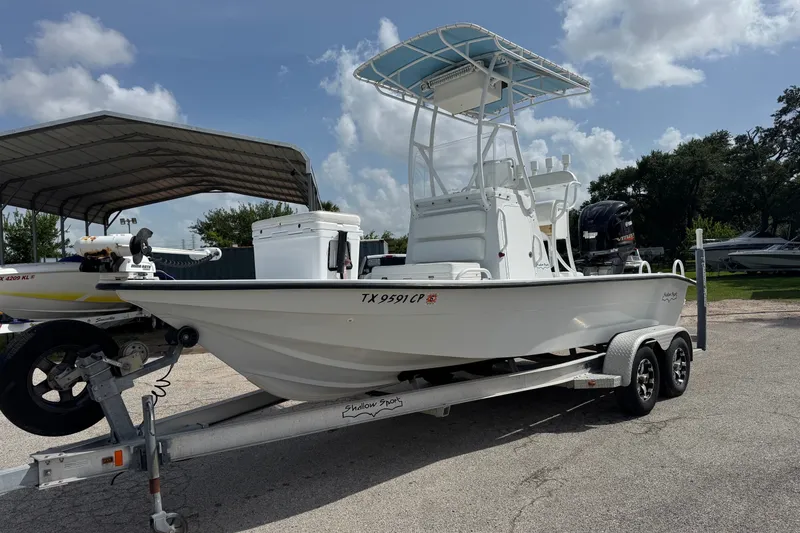 Slide: The Image of 2012 Shallow Sport 21 Modified V boat on trailer under cloudy sky. - 2