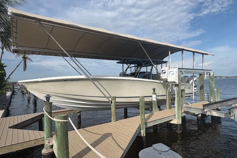 Slide: The Image of 2014 Nor-Tech 390 Sport boat docked under a canopy on a sunny day. - 1