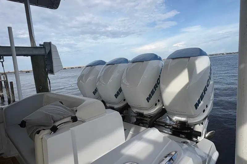 Slide: The Image of 2014 Nor-Tech 390 Sport boat with four Mercury outboard engines docked by the water. - 15