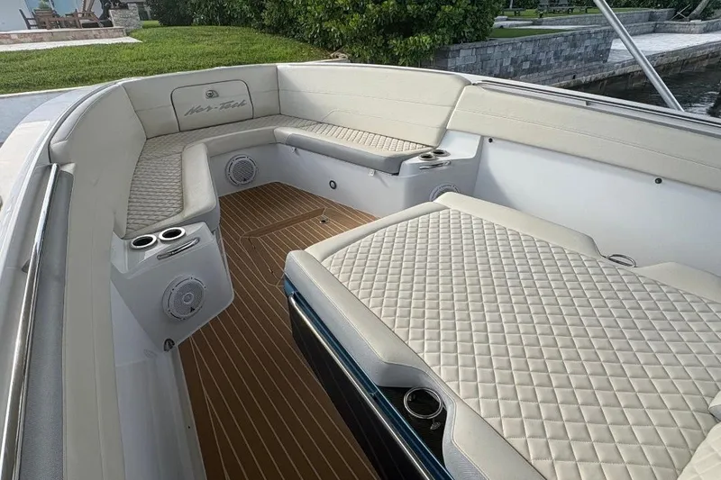 Slide: The Image of 2014 Nor-Tech 390 Sport boat interior with quilted seating and wood-style flooring. - 7