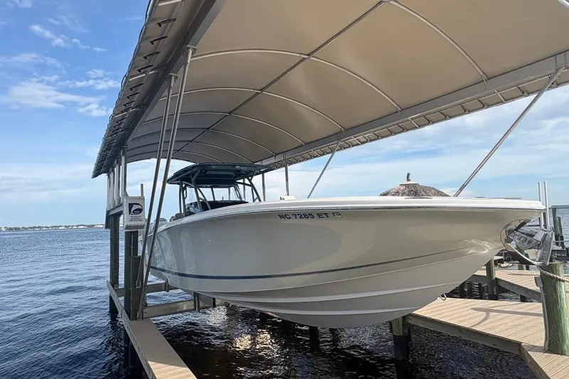 Slide: The Image of 2014 Nor-Tech 390 Sport boat docked under a canopy by the water. - 4