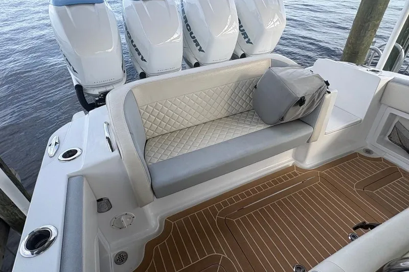Slide: The Image of 2014 Nor-Tech 390 Sport boat interior with cushioned seating and Mercury outboard engines. - 10