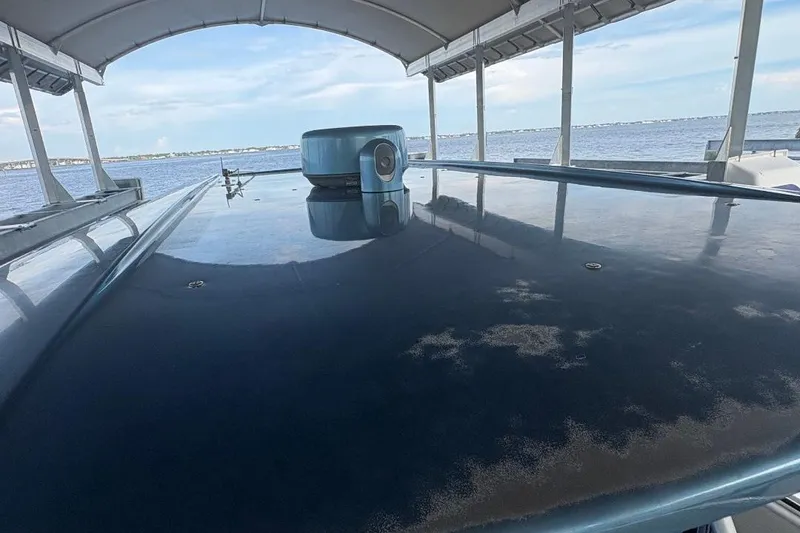 Slide: The Image of 2014 Nor-Tech 390 Sport boat under canopy, overlooking serene water view. - 11