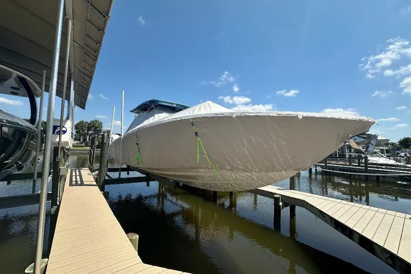 Slide: The Image of 2014 Nor-Tech 390 Sport boat covered and docked under a clear blue sky. - 5