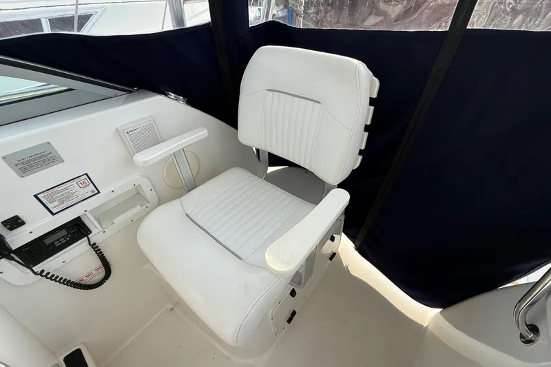 Slide: The Image of Captain's chair on a 2000 Boston Whaler 28 Conquest boat, featuring white upholstery. - 11