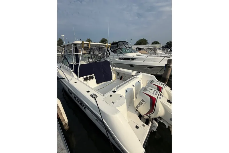 Slide: The Image of 2000 Boston Whaler 28 Conquest boat docked with twin Evinrude engines. - 2