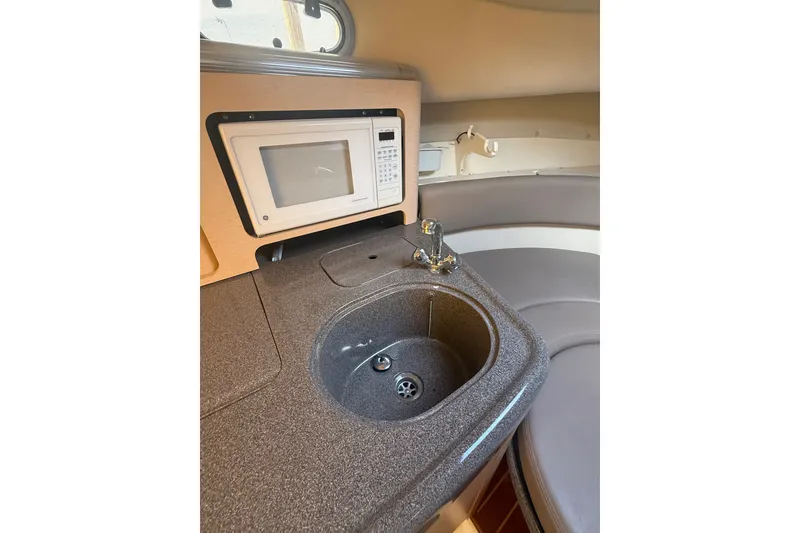 Slide: The Image of Compact kitchen area in a 2000 Boston Whaler 28 Conquest boat, featuring a sink and microwave. - 22