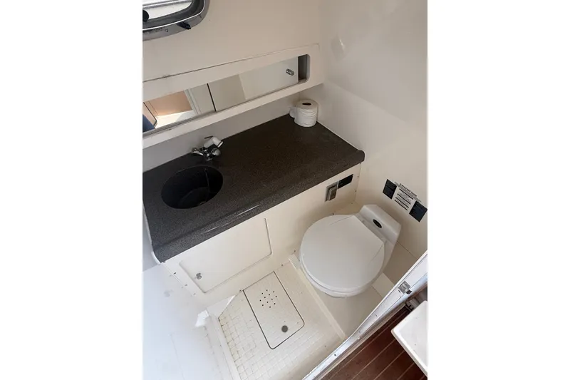 Slide: The Image of 2000 Boston Whaler 28 Conquest boat bathroom with sink, toilet, and mirror. - 24