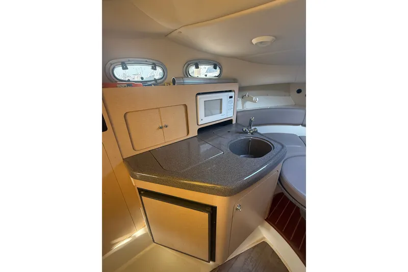 Slide: The Image of Interior of 2000 Boston Whaler 28 Conquest with kitchenette, sink, and microwave. - 23