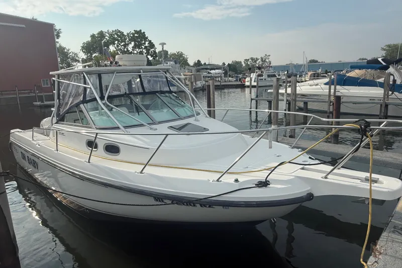The Image of 2000 Boston Whaler 28 Conquest boat docked at marina, featuring sleek design and spacious cabin. - 0