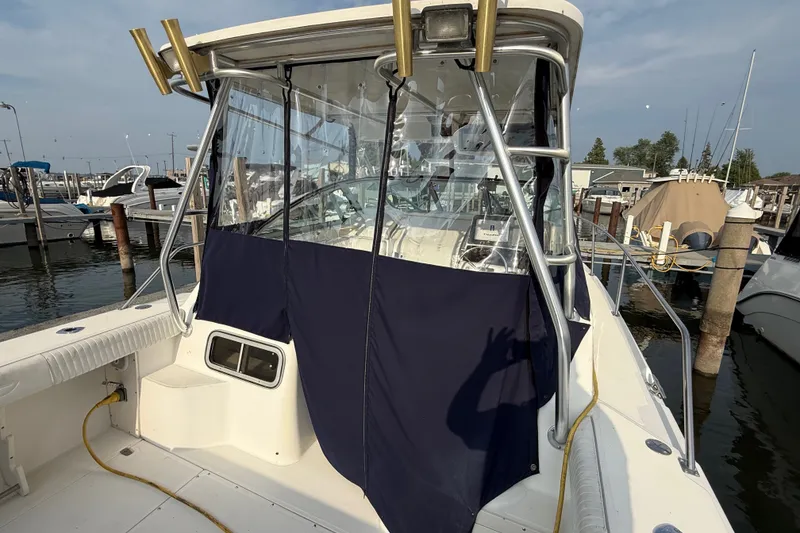 Slide: The Image of 2000 Boston Whaler 28 Conquest boat docked, featuring covered cockpit and marina background. - 8