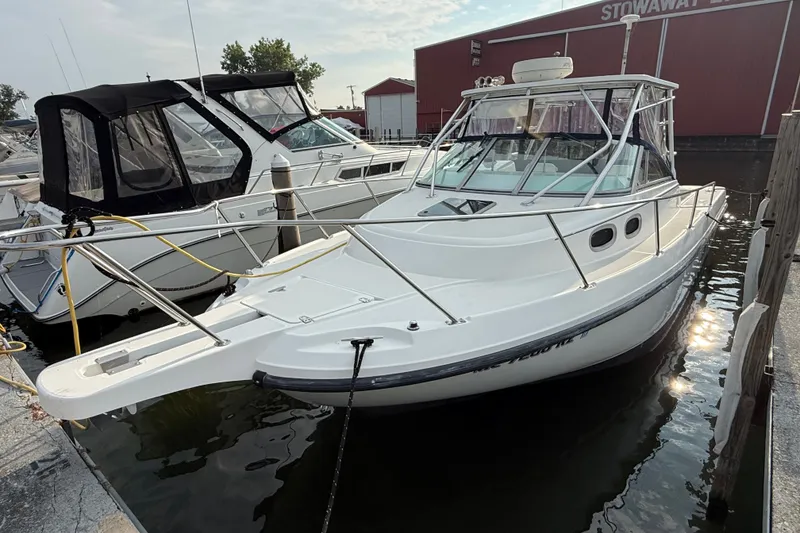 Slide: The Image of 2000 Boston Whaler 28 Conquest boat docked at marina, featuring sleek design and spacious cabin. - 1