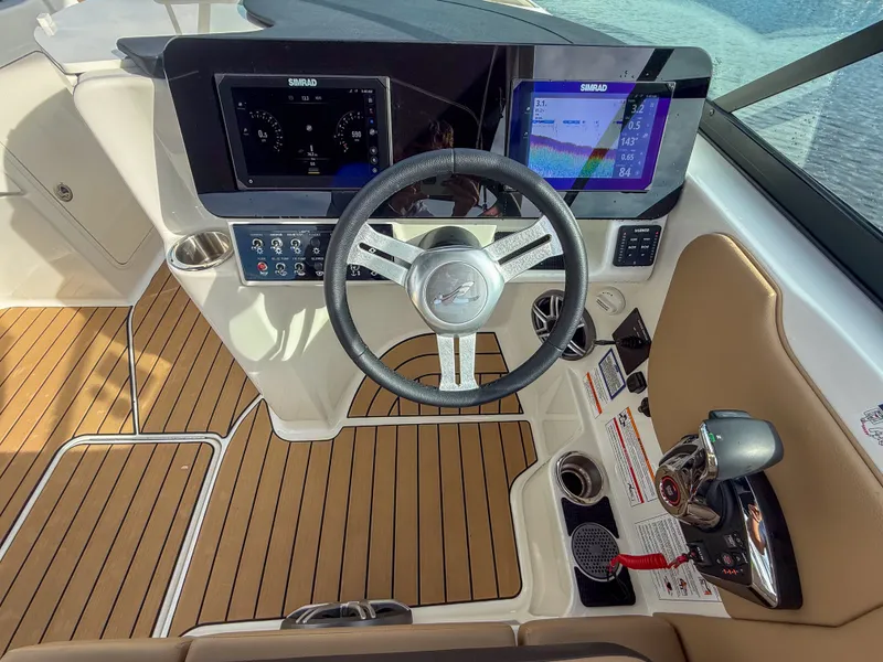 Slide: The Image of The image shows the cockpit of a Sea Ray SDX 270 Outboard with modern instruments and wood finish. - 12