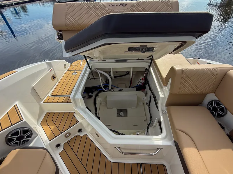 Slide: The Image of The 2027 Sea Ray SDX 270 Outboard features an open storage compartment with cushioned seats and wood flooring. - 21