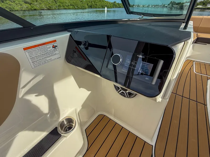Slide: The Image of The image shows the cockpit of a Sea Ray SDX 270 Outboard with modern controls and wood flooring. - 15