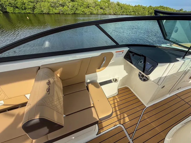 Slide: The Image of The image shows the cockpit of a 2027 Sea Ray SDX 270 Outboard with sleek seating and wood flooring. - 14