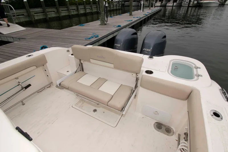 Slide: The Image of 2016 NauticStar 28 XS boat interior with seating, twin engines, and dockside view. - 6