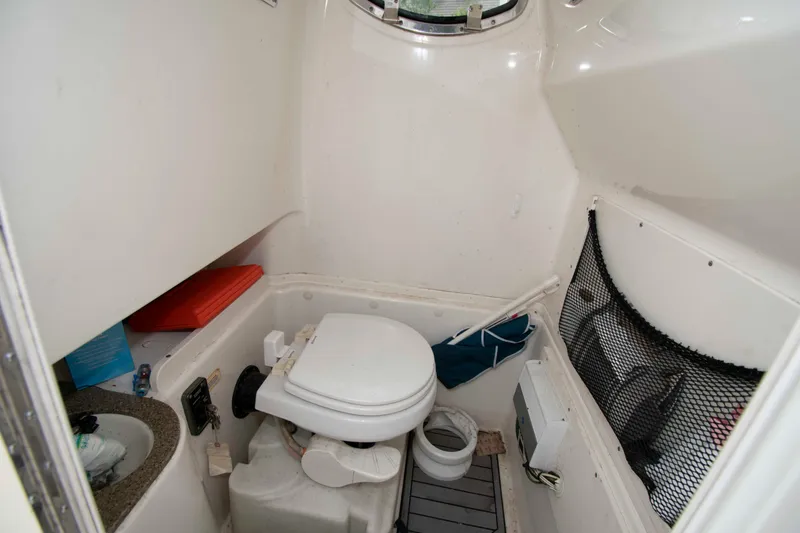 Slide: The Image of 2016 NauticStar 28 XS boat interior bathroom with toilet and storage compartments. - 19