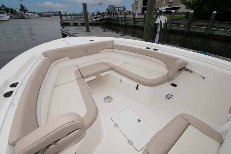 Slide: The Image of 2016 NauticStar 28 XS boat interior with spacious seating at a marina dock. - 10
