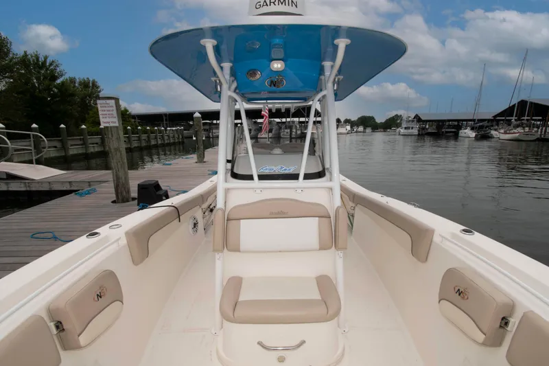 Slide: The Image of 2016 NauticStar 28 XS boat docked at marina, featuring spacious seating and Garmin equipment. - 12