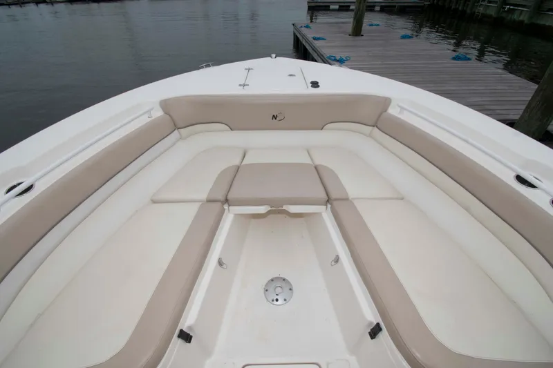 Slide: The Image of 2016 NauticStar 28 XS boat interior with beige seating, dockside view. - 11
