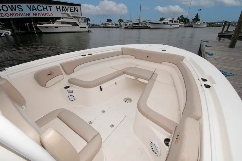 Slide: The Image of 2016 NauticStar 28 XS boat interior with beige seating at marina dock. - 8