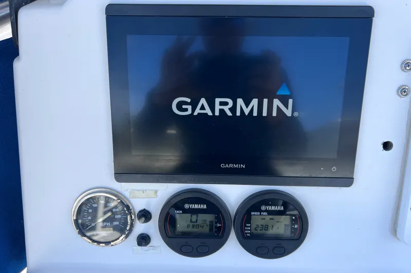 Slide: The Image of Garmin display and Yamaha gauges on 2001 Cobia 254 Center Console boat dashboard. - 22