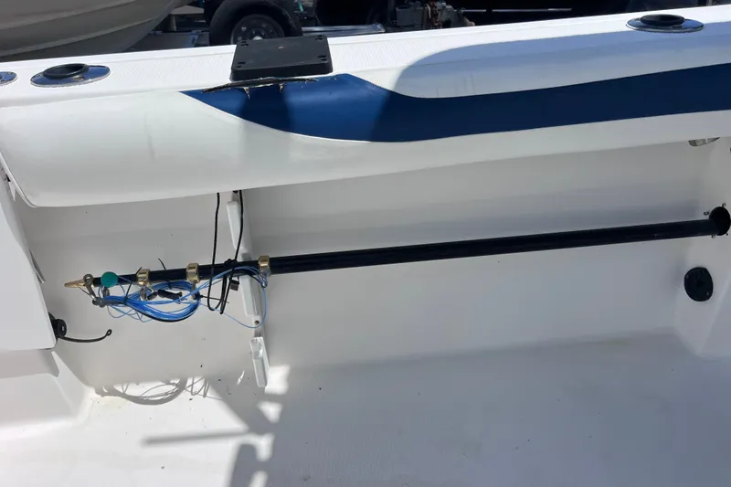 Slide: The Image of 2001 Cobia 254 Center Console boat interior with wiring and rod holder. - 14