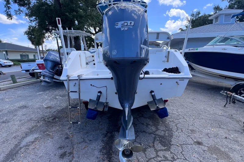 Slide: The Image of 2001 Cobia 254 Center Console boat with Yamaha outboard motor, parked on a paved surface. - 2