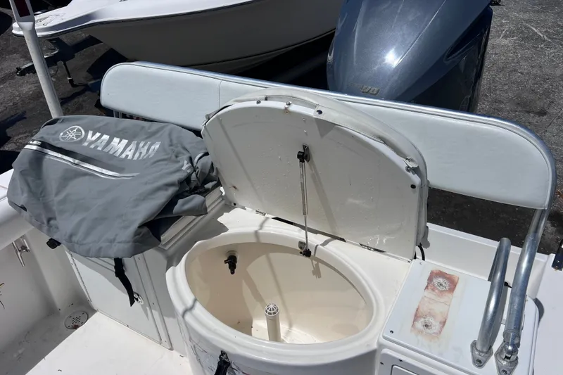 Slide: The Image of 2001 Cobia 254 Center Console boat with Yamaha cover and open storage compartment. - 11