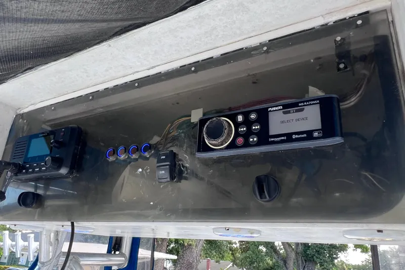 Slide: The Image of Center console electronics on a 2001 Cobia 254 boat, featuring a Fusion marine stereo. - 32