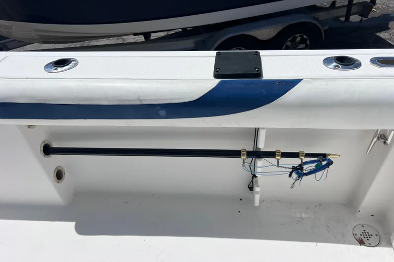Slide: The Image of 2001 Cobia 254 Center Console boat interior with rod holder and fishing gear. - 12