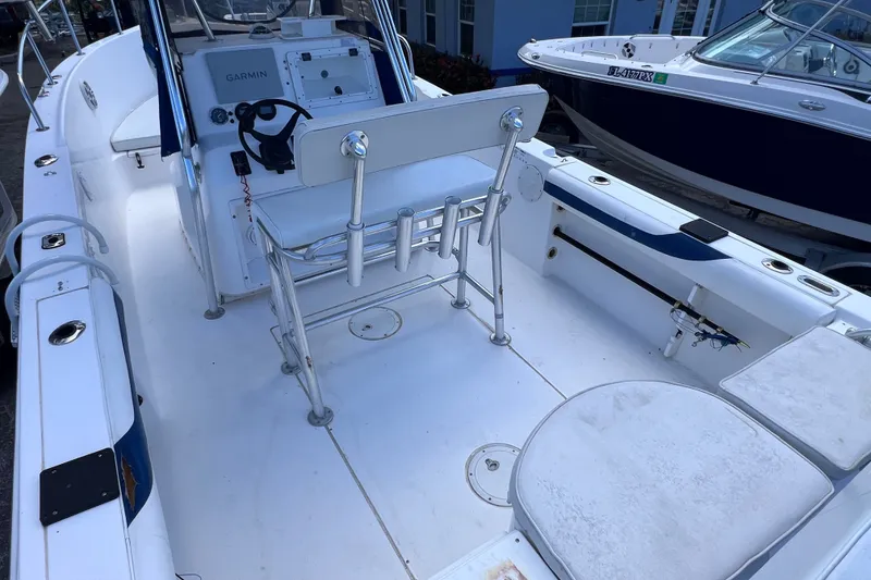Slide: The Image of 2001 Cobia 254 Center Console boat interior with seating and Garmin navigation system. - 9
