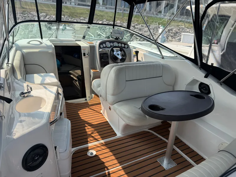 Slide: The Image of The image shows the cockpit of a 2004 Chaparral Signature 240 with white seating and wood flooring. - 6