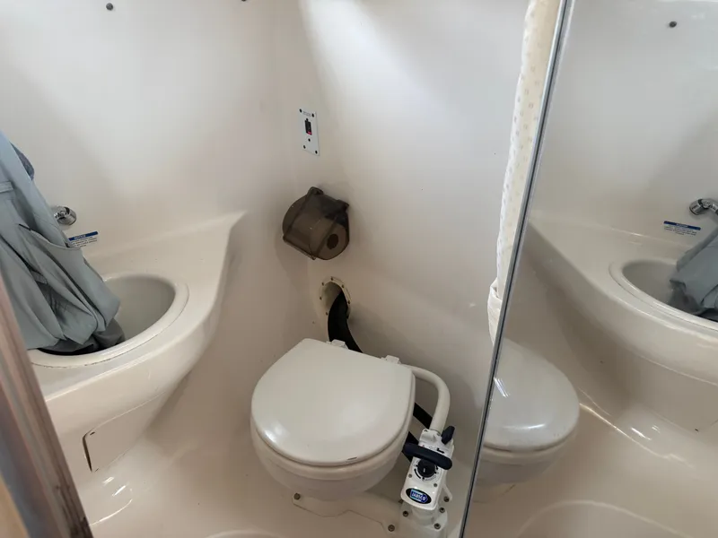 Slide: The Image of The image shows a boat bathroom with a toilet and a sink. - 12
