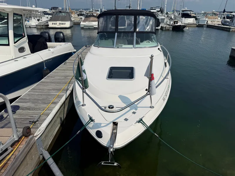 Slide: The Image of A white boat docked at a pier, surrounded by other boats in the harbor. - 3