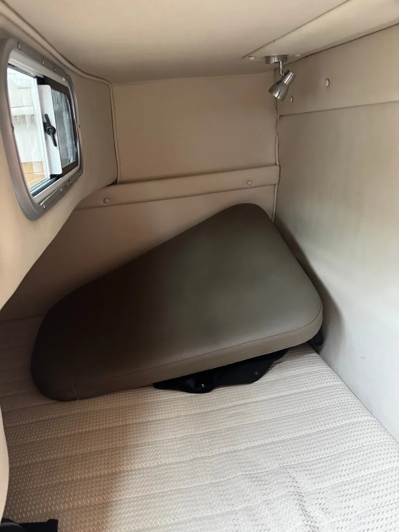 Slide: The Image of Interior of a 2004 Chaparral Signature 240 with cushioned seating and a window. - 10