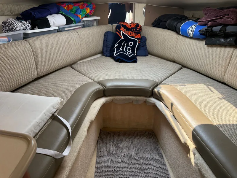 Slide: The Image of The interior of a 2004 Chaparral Signature 240 features a cozy seating area with cushions. - 11