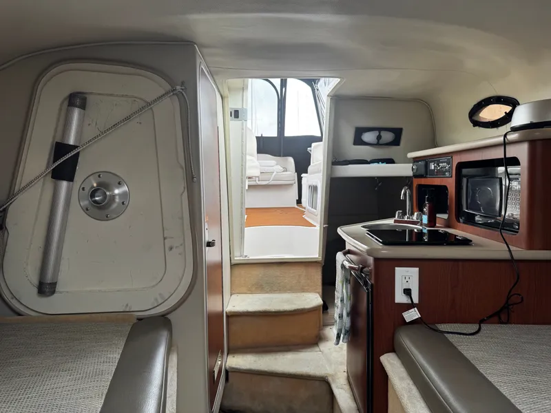 Slide: The Image of Interior of a 2004 Chaparral Signature 240 with kitchenette, seating area, and sleeping space. - 8