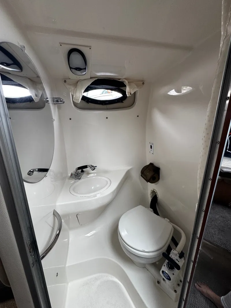 Slide: The Image of The image shows a compact boat bathroom with a toilet, sink, and porthole. - 7