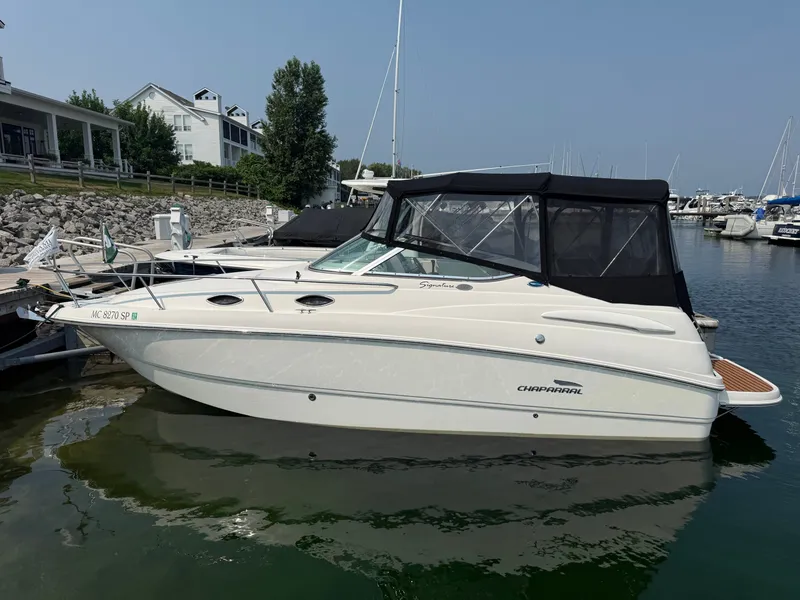 Slide: The Image of A 2004 Chaparral Signature 240 docked, featuring a black canopy and sleek design. - 1