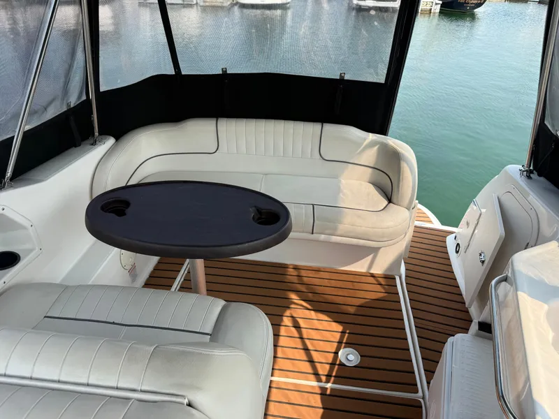 Slide: The Image of The image shows the interior of a Chaparral Signature 240 boat with beige seating and a table. - 7