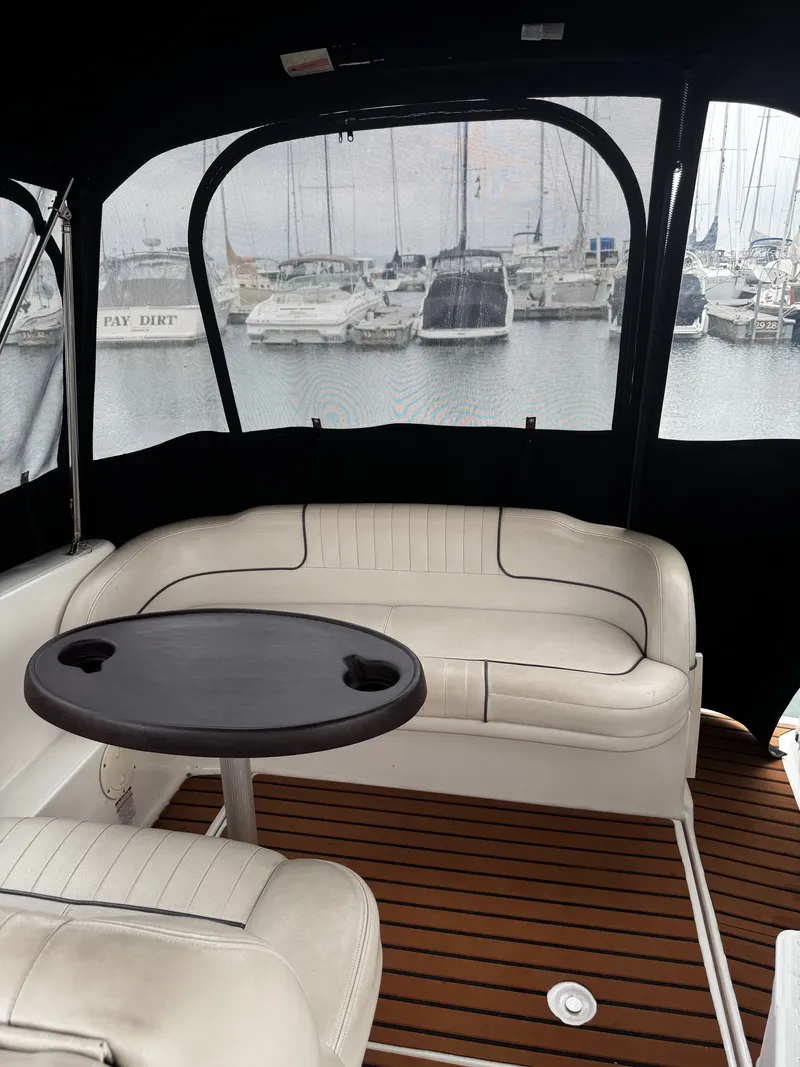 Slide: The Image of The image shows the interior of a 2004 Chaparral Signature 240 boat with white seating and a table. - 3
