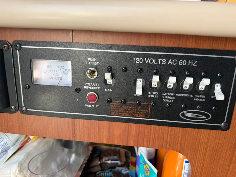Slide: The Image of An electrical panel with switches and a voltage meter in a Chaparral Signature 240 boat. - 13