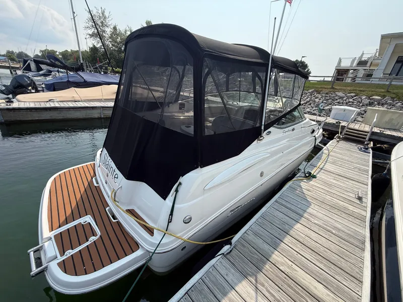 Slide: The Image of A 2004 Chaparral Signature 240 boat docked. It features a black canopy. - 5