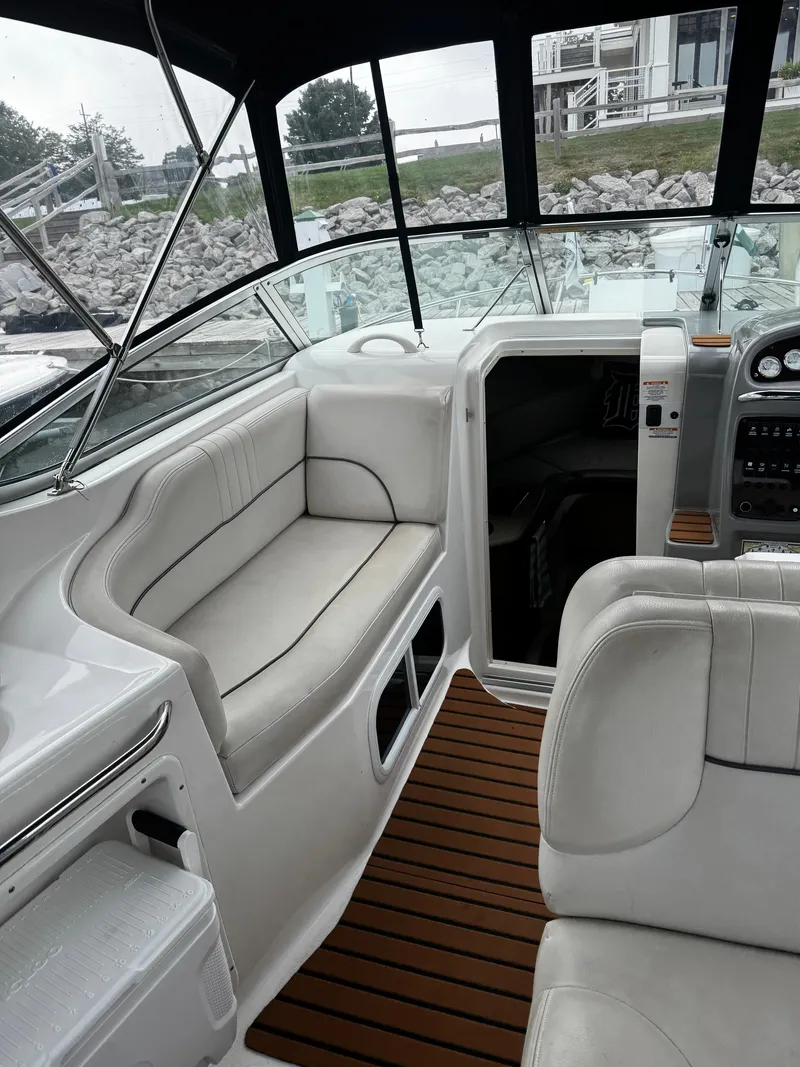Slide: The Image of The image shows the cockpit of a 2004 Chaparral Signature 240 with white seating and wood flooring. - 2